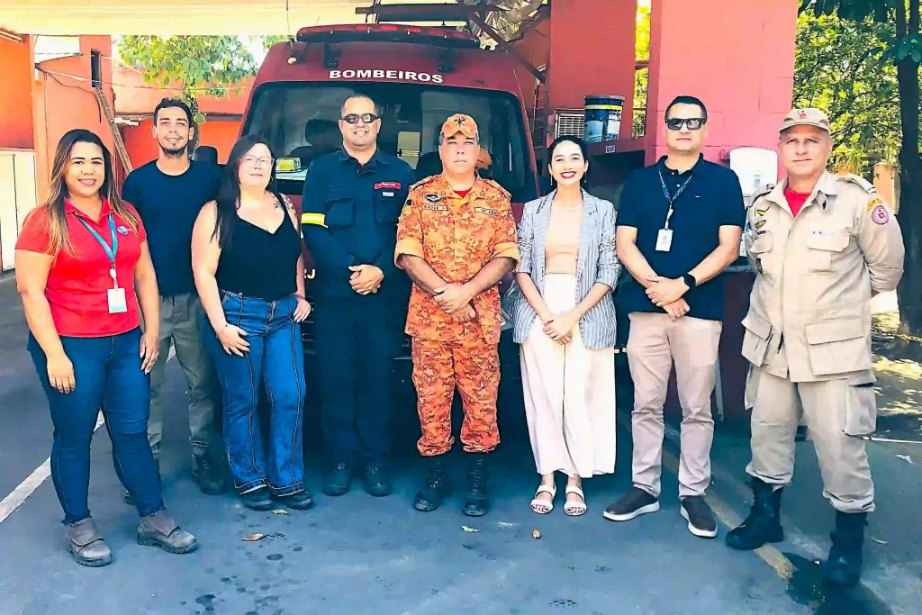 representantes da AEDIN e do Corpo de Bombeiros de Itaguaí fazem pose para registro da foto em frente ao prédio da corporação